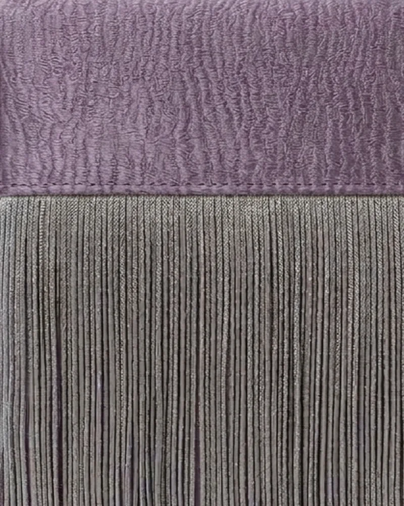 Detalle de la piel violeta texturizada y los flecos grises del bolso Cassis